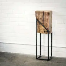  ??  ?? A mix of steel and wood is popular in today’s furniture, and this mini tower — encompassi­ng a section of ancestral barn beam, oiled for a finish — is a case in point. Not only is it eye-catching on its own, but it serves as an effective display stand for any ornament or plant.