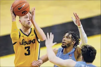  ?? Charlie Neibergall / Associated Press ?? Iowa guard Jordan Bohannon (3) shoots over North Carolina's R.J. Davis, center, and former Guilderlan­d star Andrew Platek, who finished with 10 points off the Tar Heels’ bench.