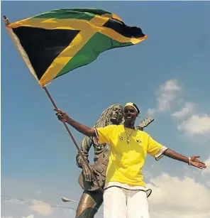  ?? Picture: Michael Steele/Empics via Getty Images ?? A Jamaican fan in front of a statue of Bob Marley.