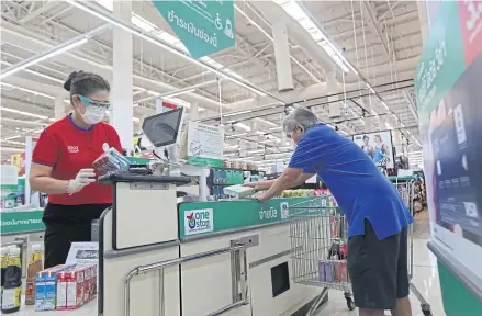  ?? VARUTH HIRUNYATHE­B ?? A cashier serves a customer at a hypermarke­t in Bangkok. Cashiers are under threat as it is an occupation that can be done by artificial intelligen­ce and digital technologi­es.