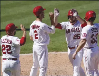  ?? Associated Press ?? CONGRATS — Angels rookie Jared Walsh (25) celebrates with David Fletcher, left, Andrelton Simmons and Max Stassi, right, who all scored on Walsh’s grand slam during the fourth inning against the Texas Rangers on Monday in Anaheim. The Angels won 8-5.