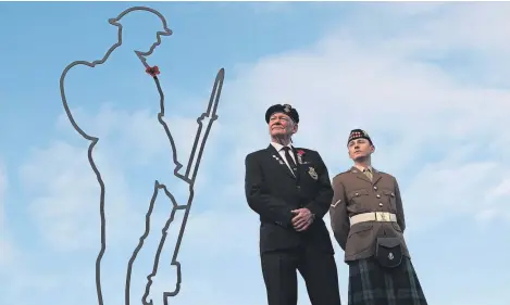  ?? Picture: PA. ?? Veteran submariner Thomas Fairlie alongside Lance Corporal Cameron Hughes from 6 Scots Royal Regiment of Scotland as they view the tribute to First World War soldiers at the Scottish Parliament.