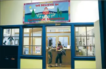  ?? Photograph­s by Gary Coronado Los Angeles Times ?? NORA ROE and her son Hunter, 6, an incoming first-grader at Mount St. Mary’s Academy, wait in the school office after he took an assessment examinatio­n. She said Hunter is eager to return to in-person instructio­n.