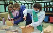  ??  ?? Troop leader Sarah Wayland helps Girl Scouts with Troop 50398, including Elizabeth Smith and Bridget Casey, put together bat boxes at the Rowayton Community Center in Norwalk Friday.