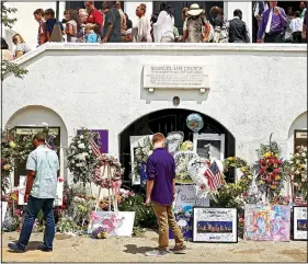  ?? The New York Times/TRAVIS DOVE ?? Flowers, photos and other items are left in memorial to parishione­rs killed by a gunman at Emanuel African Methodist Episcopal Church in Charleston, S.C., as Sunday service ends in June of 2015.