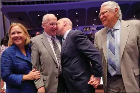  ?? (AP) ?? Former New Orleans Mayor Moon Landrieu is kissed by his son, outgoing New Orleans Mayor Mitch Landrieu, during a photo session with his daughter, former Sen. Mary Landrieu, and Sidney Barthelemy (right), also a former mayor of the city, at the mayoral inaugurati­on on May 7, 2018 in New Orleans.