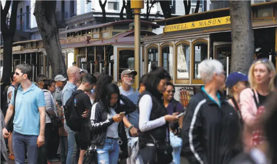  ?? Paul Chinn / The Chronicle ?? Passengers sometimes wait in line for up to two hours to board cable cars at the turnaround at Powell and Market streets after paying $7 for the ride tickets.