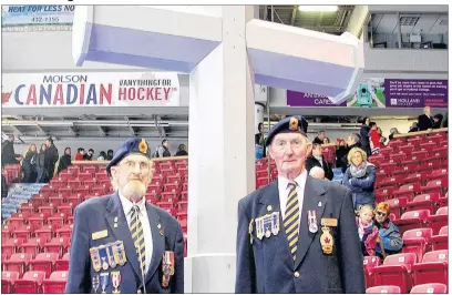  ?? DESIREE ANSTEY/ JOURNAL PIONEER ?? Veteran’s Henry Woodard “Woody” and Austin McLellan stand sharp in front of the cross in the arena of the Credit Union Place for the Remembranc­e Day service, Saturday morning.