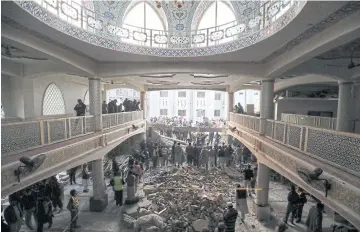  ?? REUTERS ?? People and rescue workers look for survivors after a suicide blast at a mosque in Peshawar on Monday.