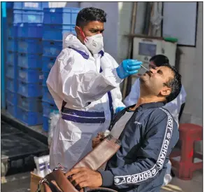  ?? (AP/Altaf Qadri) ?? A health care worker conducts random covid-19 tests Saturday in front of a shop on the outskirts of New Delhi.