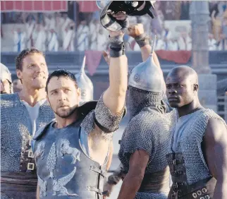  ??  ?? Russell Crowe, centre, plays Maximus, while gladiators Juba, played by Djimon Hounsou, right, and Hagen, played by Ralf Moeller, left, salute the crowd in Gladiator. The film has a score drawing strongly on the music of Holst.