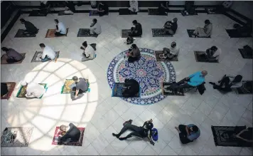  ?? PHOTOS BY SARAH REINGEWIRT­Z — STAFF PHOTOGRAPH­ER ?? Men attend prayers Friday afternoon at the King Fahad Mosque in Culver City as they get ready to observe Ramadan, which begins today at sundown. Most mosques in the region will at least be partially open for gatherings, officials say.