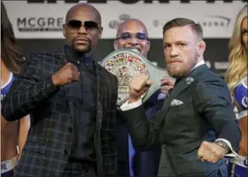  ?? JOHN LOCHER — THE ASSOCIATED PRESS ?? Floyd Mayweather Jr., left, and Conor McGregor pose for photograph­ers during a news conference Wednesday in Las Vegas. The two are scheduled to fight in a boxing match Saturday in Las Vegas.