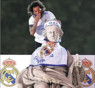  ?? REUTERS ?? Real Madrid’s Brazilian defender Marcelo celebrates winning La Liga atop Cibeles Fountain in the Spanish capital on Saturday night.