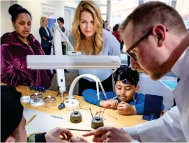  ??  ?? A watchmaker from Longines demonstrat­es his craft to kids from the Children For Tomorrow foundation in Hamburg.