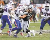  ??  ?? Raiders’ rookie linebacker James Cowser, playing in his second NFL game, sacks Bills quarterbac­k Tyrod Taylor. It was Cowser’s first career sack.