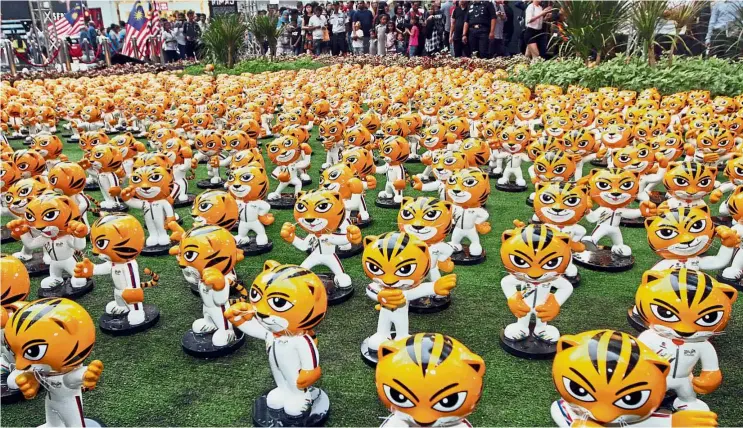  ?? — AZHAR ARIF/ The Star ?? Countdown to the Games: People admiring Rimau mascots on display at Pavillion Kuala Lumpur in conjunctio­n with the 29th SEA Games.