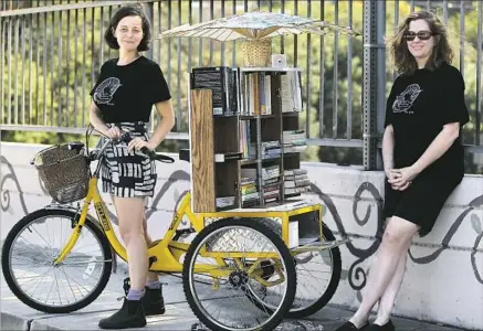  ?? Luis Sinco Los Angeles Times ?? THE FEMINIST LIBRARY on Wheels is a project of Jenn Witte, left, and Dawn Finley, who created a lending library on a bicycle.