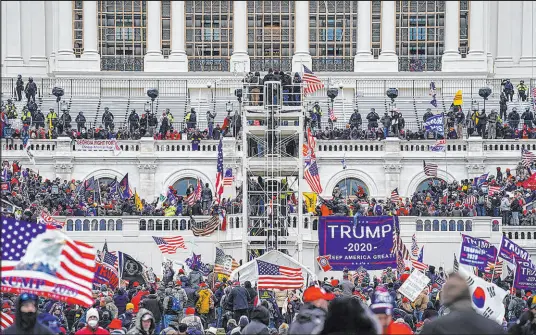  ?? John Minchillo The Associated Press ?? A mob breaches the Capitol on Jan. 6, the day Congress was certifying the results of the Electoral College vote.