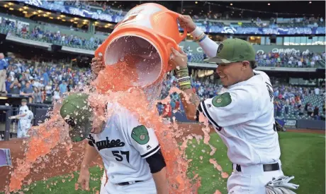  ?? ASSOCIATED PRESS ?? Brewers starting pitcher Chase Anderson gets a celebratio­n douse from Orlando Arcia after surrenderi­ng just one hit in seven-plus innings on Saturday.