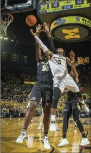  ?? TONY DING — THE ASSOCIATED PRESS ?? Michigan guard Zavier Simpson (3) goes to the basket, defended by Purdue forward Trevion Williams (50), in the second half of an NCAA college basketball game at Crisler Center in Ann Arbor, Mich., Saturday. Michigan won 76-57.