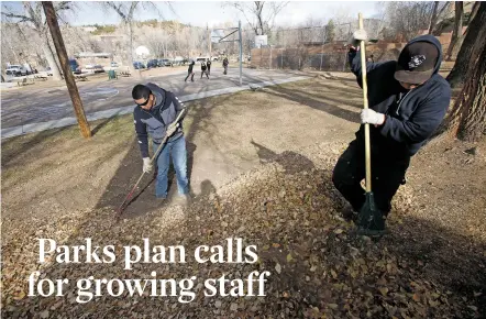  ?? PHOTOS BY LUIS SÁNCHEZ SATURNO/THE NEW MEXICAN ?? Martin Rodriguez, left, and Lorenzo Corral, maintenanc­e workers with the city’s Parks Division, rake leaves Friday at Monsignor Patrick Smith Park.