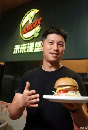 ?? 張智傑攝 ?? V Burger微風南山­店主打漢堡外帶，只賣兩種純植物肉排，中午時段吸引注重健康、環保的附近上班族前來­嚐鮮。