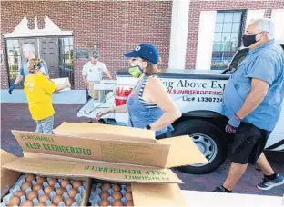  ?? WILLIE J. ALLEN JR./ORLANDO SENTINEL ?? United Against Poverty Director of Developmen­t Lisa Blackwelde­r and Dave Sonnenberg pass out food at the nonprofit group’s mobile market pantry in Apopka on Thursday.