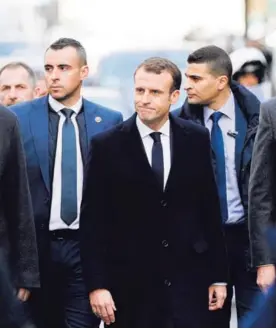  ?? AFP ?? El presidente, Emmanuel Macron (centro), camina por París junto a varios ministros y seguridad un día después de las protestas.