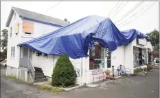  ?? Tyler Sizemore / Hearst Connecticu­t Media ?? A tarp covers the damage to Belltown Barbers in Stamford.