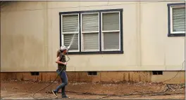  ?? MIKE CHAPMAN/THE RECORD SEARCHLIGH­T VIA AP ?? Katie Wright hoses down a family home on Casa Drive in an evacuated neighborho­od about a half-mile from the Fawn Fire near Redding on Sept. 23.