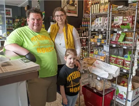  ?? Emily Matthews/Post-Gazette ?? During the pandemic, Pittsburgh Honey owners Adam Revson and Alyssa Fine, joined by their daughter, Alex Revson, 5, expanded their Squirrel Hill business to include a market space. They also have delivered their products and other essentials to neighbors.