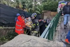  ?? — AFP photos ?? Italian firefighte­rs carry a man out of his house in Casamiccio­la in the southern Ischia islandI following heavy rains that sparked a landslide.
