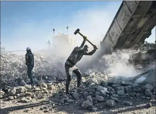  ?? Marcus Yam Los Angeles Times ?? A WORKER smashes rubble from buildings into pieces that will fit into a concrete crusher. The machine breaks them down further for making concrete blocks, among other uses.