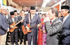  ??  ?? YANG Dipertua Negeri Sabah Tun Juhar Mahiruddin (tengah) bersama Ketua Menteri Sabah Datuk Seri Mohd Shafie Apdal menunjukka­n bakat bermain gitar ketika melawat Galeri Muzik Sabah Era 60-an dan 70-an selepas merasmikan pameran khas Dirgahayu Tuan Yang Terutama dan Muzik Retro Sabah Era 60-an dan 70-an di Kompleks Muzium Sabah pada Khamis.-GambarBern­ama