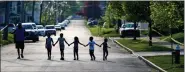  ?? AP PHOTO/MATT ROURKE, FILE ?? Children walk hand in hand May 15in a street near the scene of a shooting at a supermarke­t in Buffalo, N.Y.