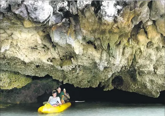  ?? Photograph­s by Sharyl McGrew ?? SEA KAYAKERS paddle around the limestone cliffs of a verdant islet in Phang Nga Bay. There are more than 40 such islets in the small inlet of the Malay Peninsula.