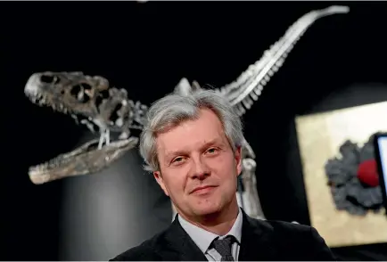  ?? PHOTOS: AP ?? Drouot auction house president Alexandre Giquello poses with a Jurassic period (161-145 million years ago) dinosaur skeleton of an Allosaurus jimmadseni.