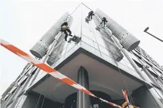  ??  ?? Workers clean the windows of the shared building which houses the offices of Cambridge Analytica in central London. — AFP photo