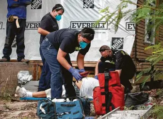  ?? Yi-Chin Lee / Staff photograph­er ?? Houston Fire Station 9 Firefighte­rs Cody Heck, from left, Ray Garza and Capt. James Rowe care for a worker injured in a constructi­on accident on Friday.