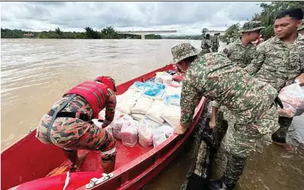  ?? (Foto Mohd Roji Kawi/bh) ?? Anggota pasukan keselamata­n menggunaka­n bot menghantar bekalan makanan kepada mangsa banjir di Bintulu.