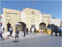  ?? (Muath Freij/Reuters) ?? SECURITY FORCES stand guard outside a court that sentenced a former royal confidant, Bassem Awadallah, alongside a minor royal to 15 years in jail on charges of attempting to destabiliz­e the monarchy yesterday in Amman.