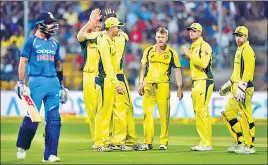  ??  ?? Australian players celebrate the fall of Virat Kohli during the fourth ODI in Bangalore on Thursday.