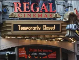 ?? PHOTO BY EVAN AGOSTINI — INVISION/AP ?? Regal Cinemas on 42nd Street is temporaril­y closed due to COVID-19 on March 5 in New York. Regal Cinemas, the second largest movie theater chain in the U.S., will reopen beginning April 2, its parent company, Cineworld Group, announced Tuesday.