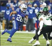  ?? Associated Press ?? Indianapol­is Colts’ Jonathan Taylor (28) runs against New York Jets’ Bryce Hall (37) during the first half of an NFL football game on Thursday in Indianapol­is.