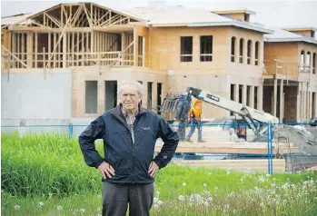  ?? MARK VAN MANEN ?? Richmond councillor and farmer Harold Steves stands in front of a mega-mansion under constructi­on in Richmond. He says offshore buyers appear to be pushing up farmland prices in order to build mega-mansions while planting minimal hobby farm produce in...