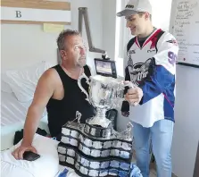  ?? JASON KRYK ?? Spitfires season-ticket holder Dan Klinck, left, gets a hospital visit from Spits forward Cristiano DiGiacinto with the Memorial Cup.