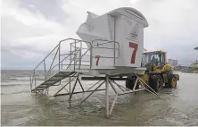  ?? Tony Giberson / Pensacola News Journal ?? A lifeguard stand is removed from flooded Pensacola Beach, Fla., as Hurricane Sally spins offshore in the Gulf of Mexico.