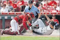  ?? [JOHN MINCHILLO/THE ASSOCIATED PRESS] ?? Reds catcher Tucker Barnhart tags out the Brewers’ Neil Walker at home in the first inning, completing a double play started by center fielder Billy Hamilton, who caught a fly ball by Travis Shaw and fired to the plate to nail Walker.