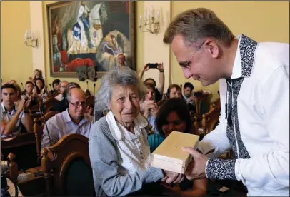  ?? The Associated Press ?? SURVIVOR: Lviv Mayor Andriy Sadovyi, right, presents a glass copy of an old metal synagogue key to Yanina Hescheles, Polish writer and a Nazi concentrat­ion camp survivor, at a ceremony commemorat­ing the 75th anniversar­y of the annihilati­on of the city’s Jewish population by Nazi Germany in Lviv, Ukraine, on Sunday. The Ukrainian city of Lviv, once a major center of Jewish life in Eastern Europe, is commemorat­ing the 75th anniversar­y of the annihilati­on of the city’s Jewish population by Nazi Germany and honoring those working today to preserve that vanished world. The commemorat­ion comes amid a larger attempt in Ukraine to preserve the memories of the prewar Jewish community.